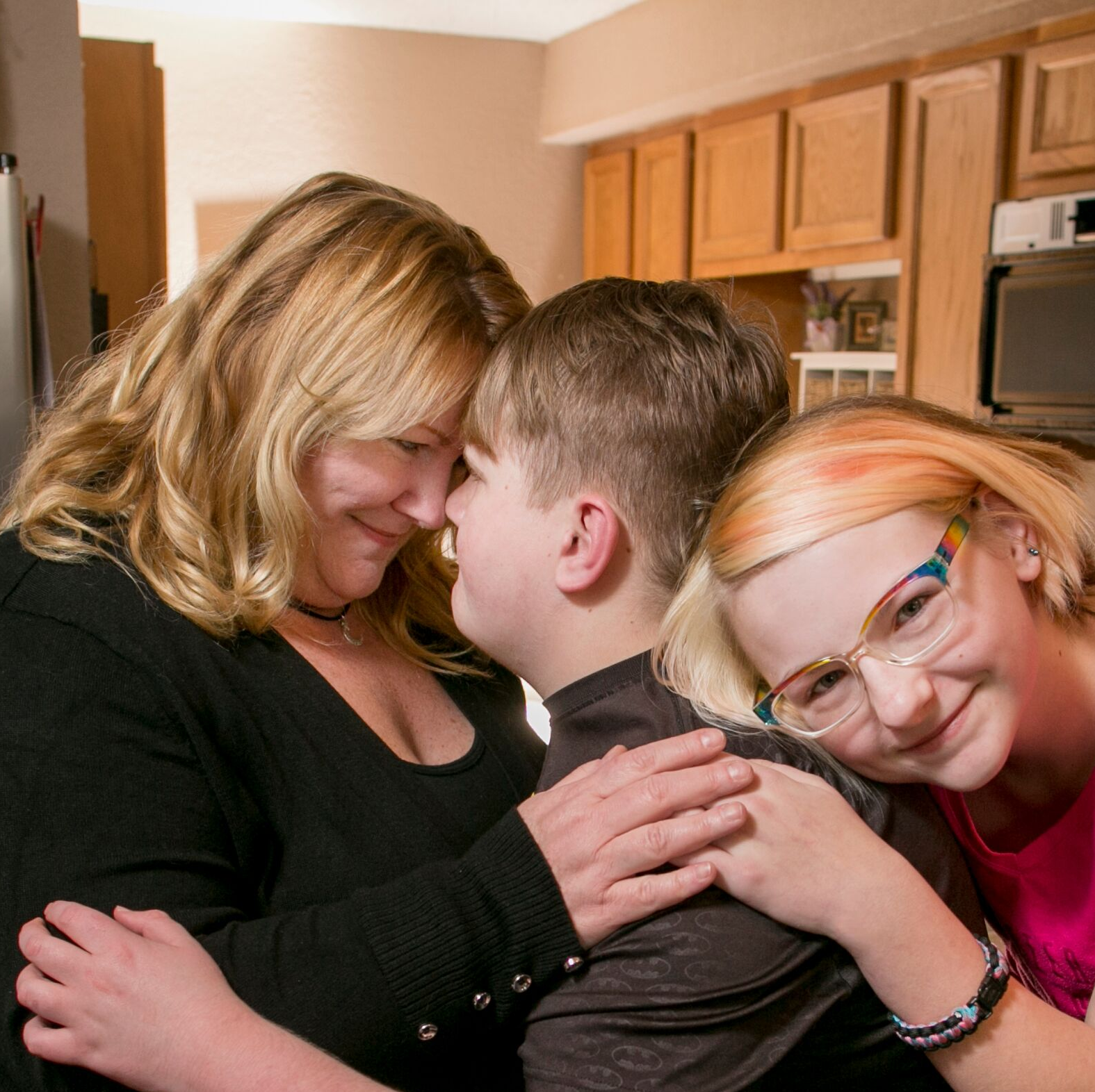 Shannon and her two children in their kitchen smiling.