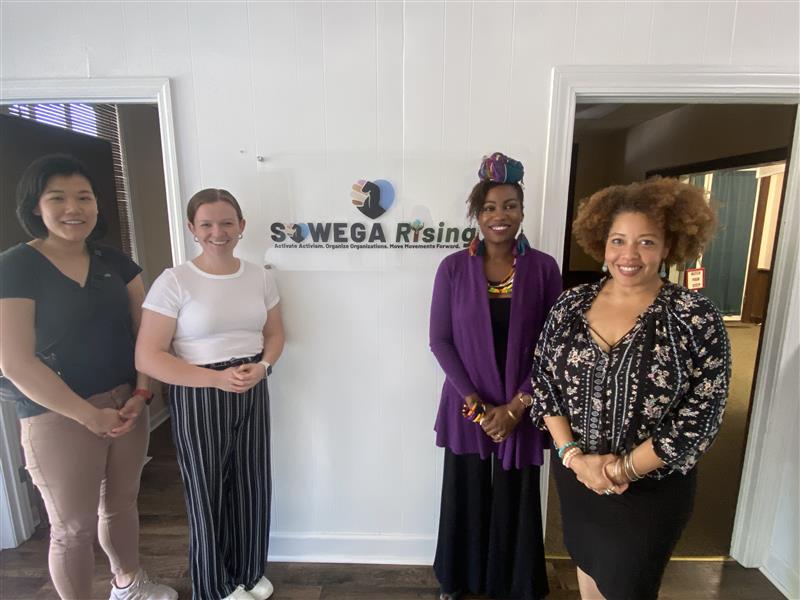 Four people stand in front of lobby of SOWEGA Rising office in Albany, Georgia.