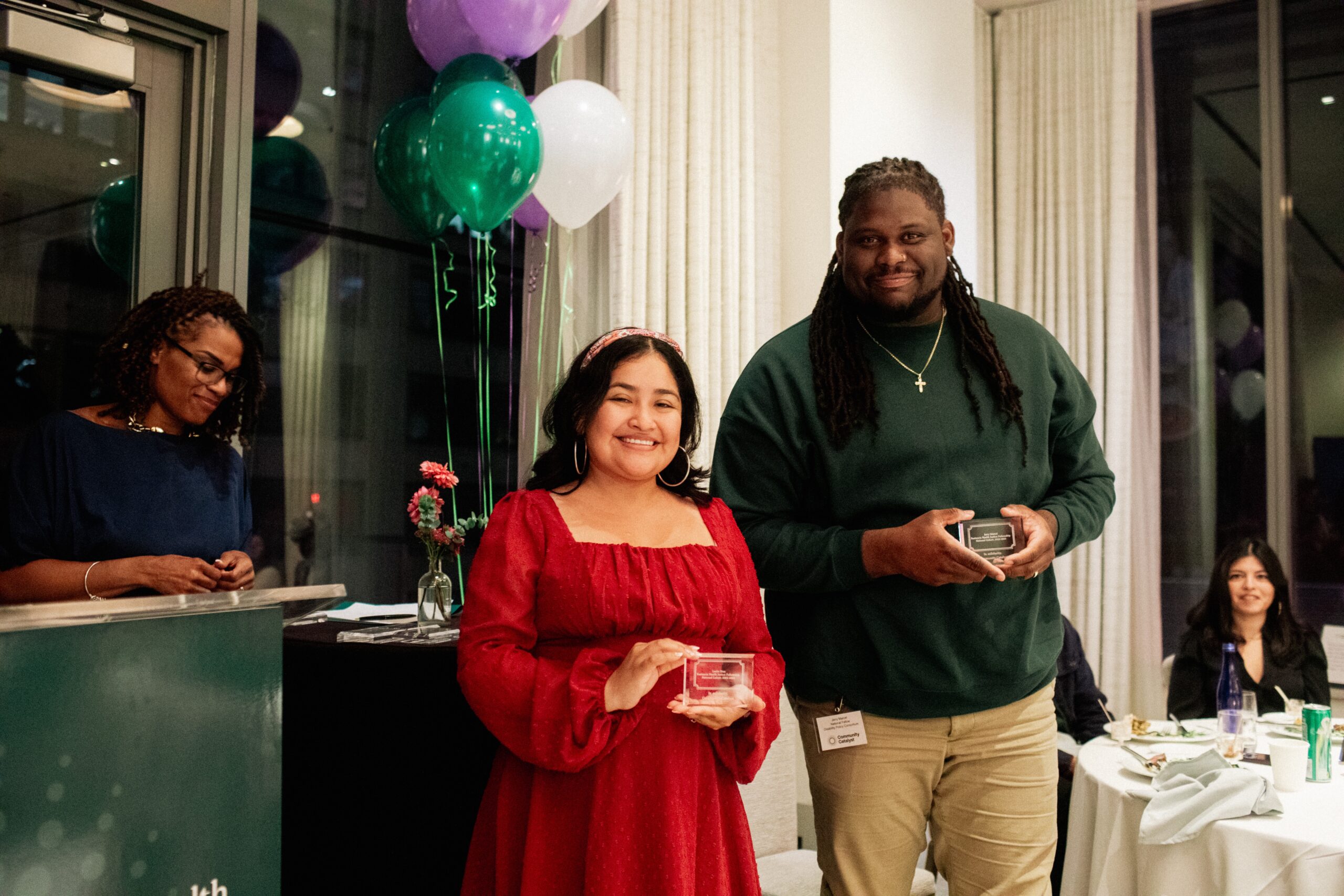 Leslie Diaz and Jerry Marcel of Disability Policy Consortium (DPC) pose together at the 2023 Restuccia Health Justice graduation event in New York. They are each holding a clear plaque.