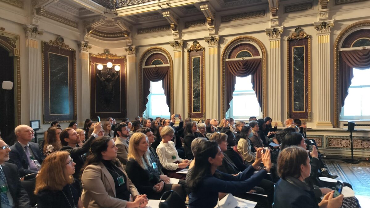 A crowd of health equity advocates sit in the White House.