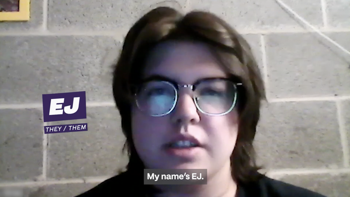 Video still of EJ speaking in front of a concrete wall. A caption at the left of the image shares EJ's name and they/them pronouns. A caption at the bottom of the screen also reads "My name's EJ."