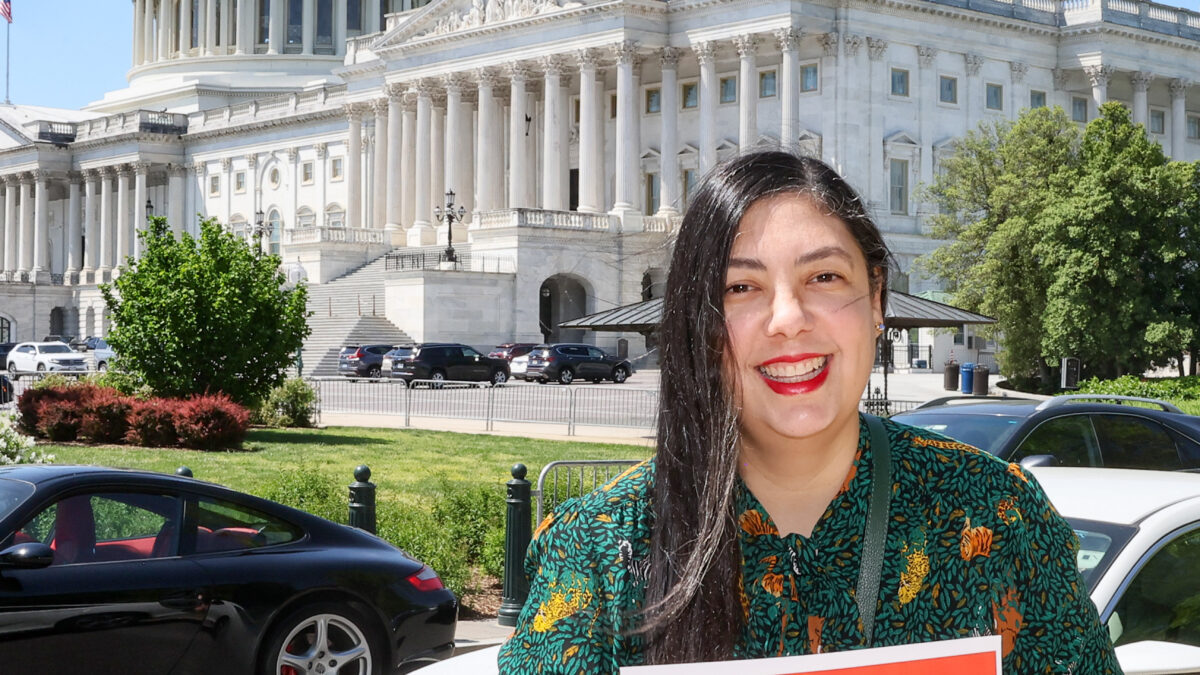 A woman smiles in front of the U.S. capitol holding a sign that says "Care. Not collections."