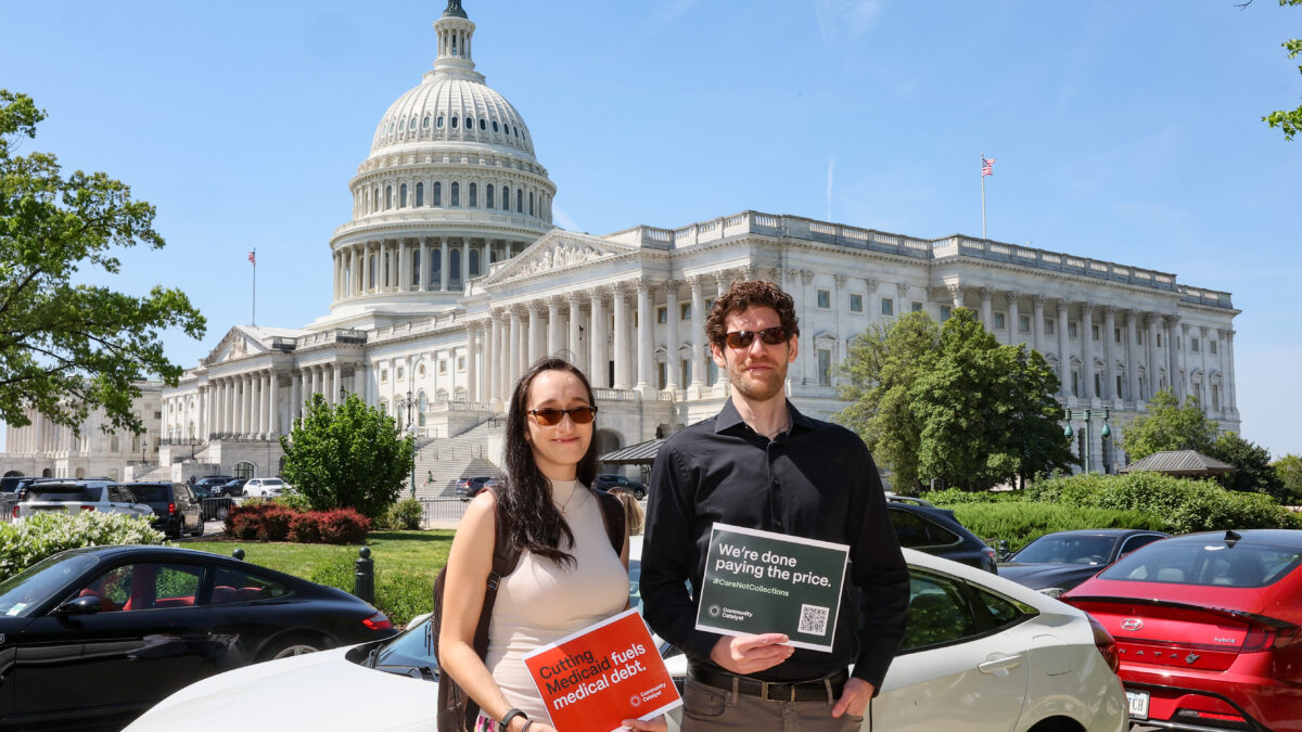Two people pose in front of the Capitol with signs that read "Cutting Medicaid fuels medical debt" and "We're done paying the price."