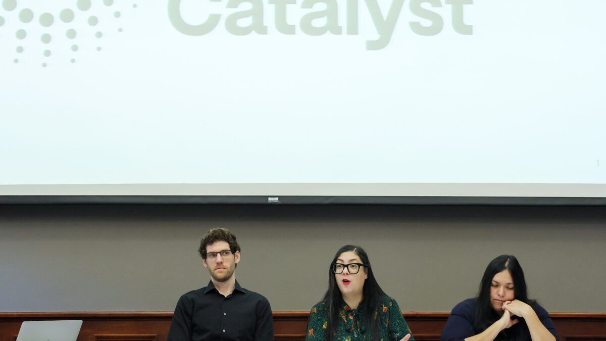 Three people sit at a roundtable in Washington, D.C. with a Community Catalyst sign displayed on the wall behind them.