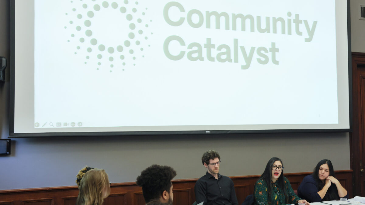 Five people sit at a roundtable in Washington, D.C. with a Community Catalyst sign displayed on the wall behind them.