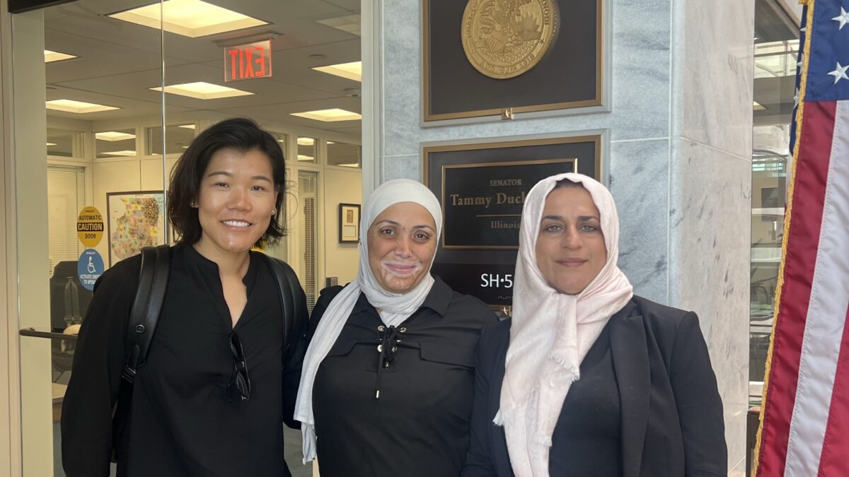 Three people stand inside a building on Capitol Hill in Washington, D.C.