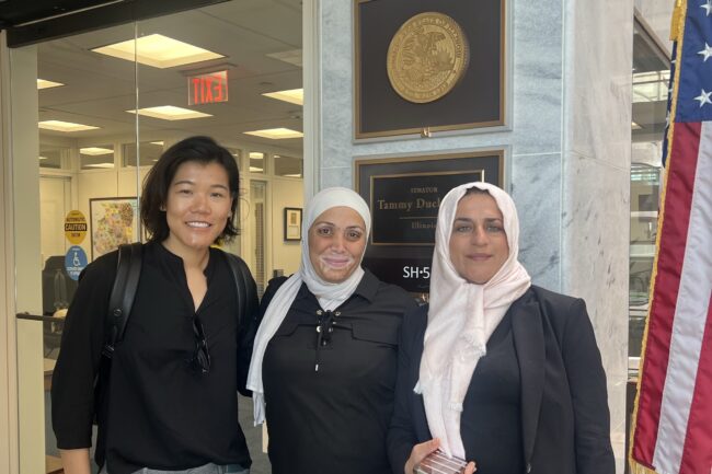 Three people stand inside a building on Capitol Hill in Washington, D.C.
