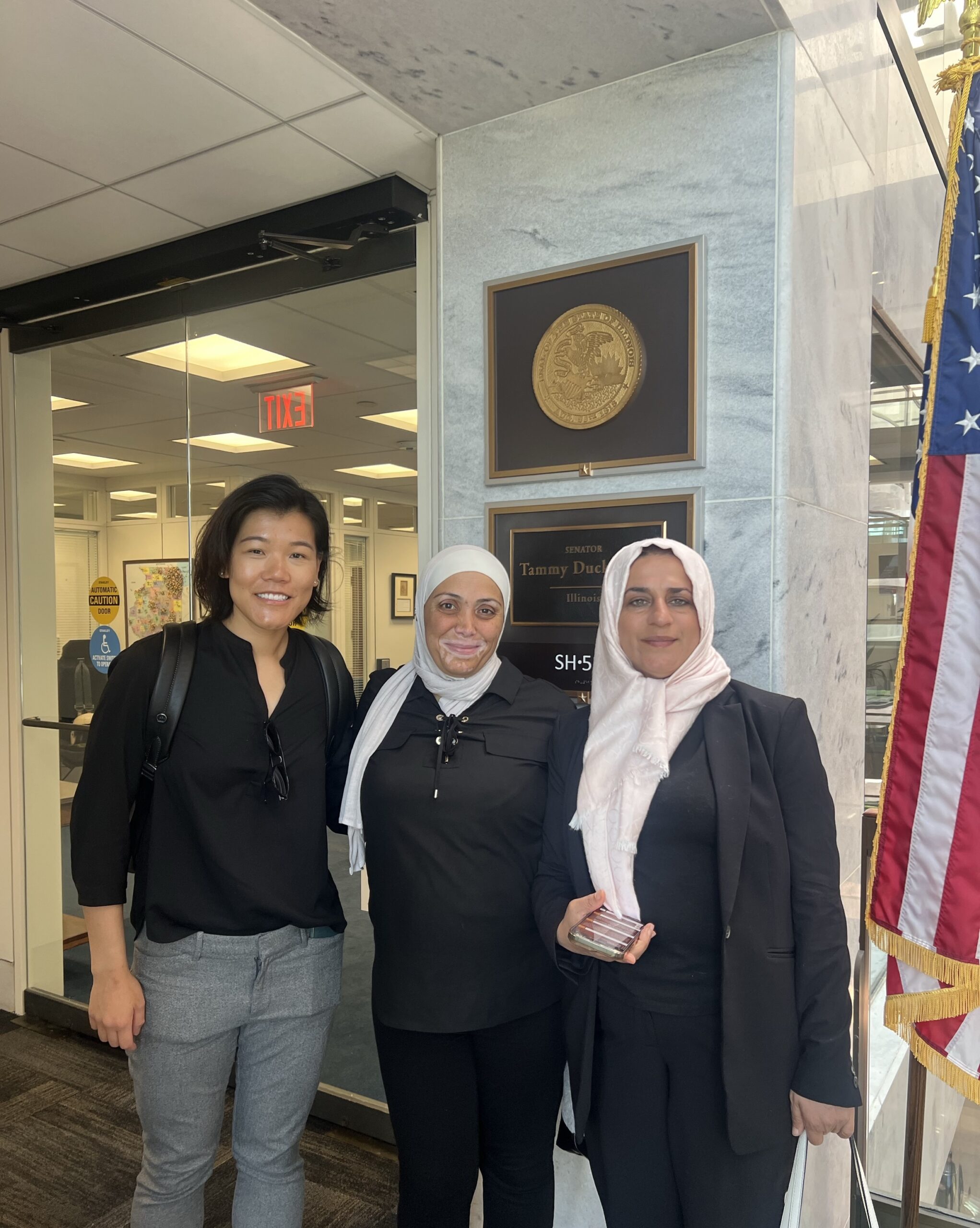 Three people stand inside a building on Capitol Hill in Washington, D.C.