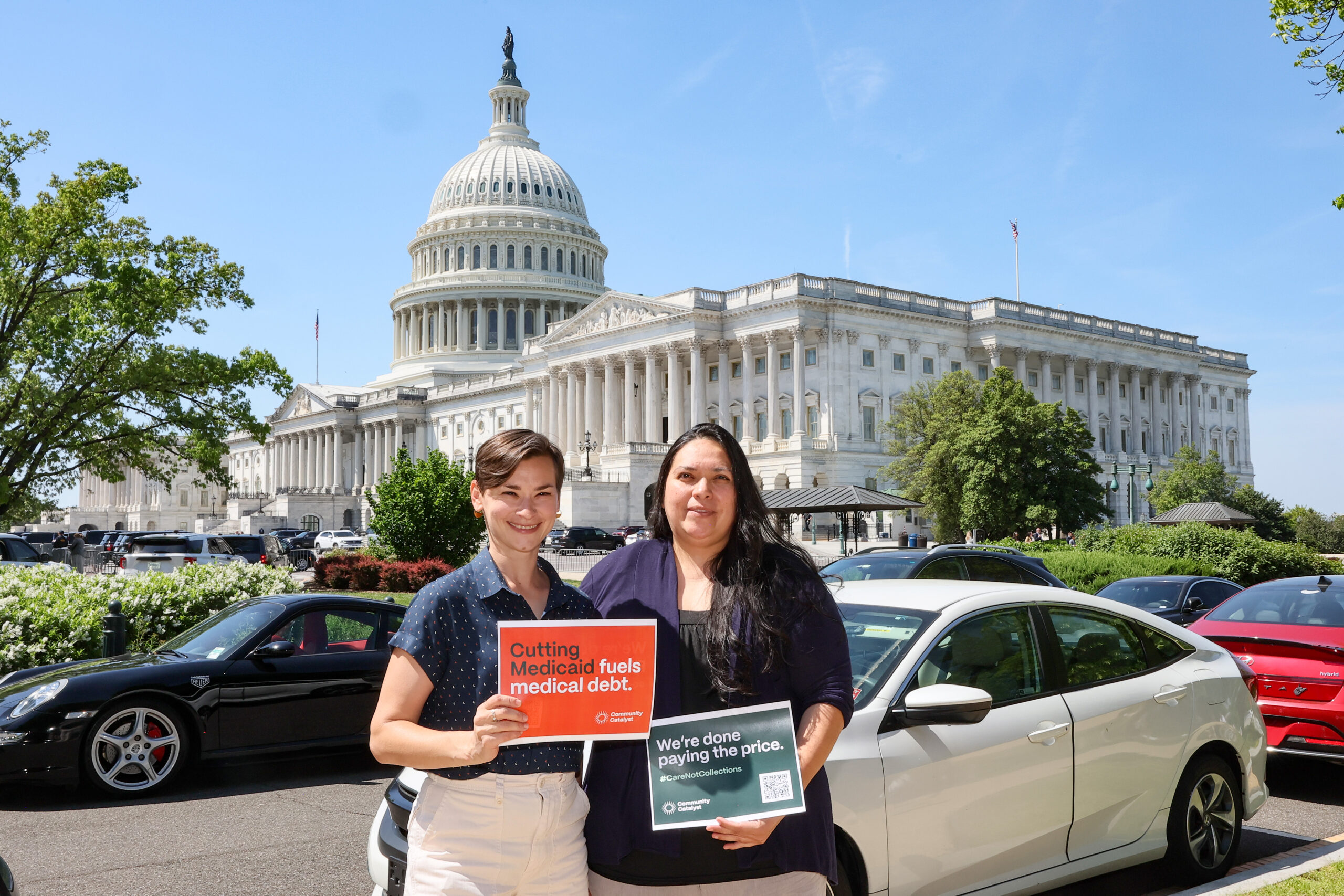 Two people pose in front of the Capitol in Washington, D.C. They are holding signs that read, "Cutting Medicaid fuels medical debt" and "We're done paying the price."