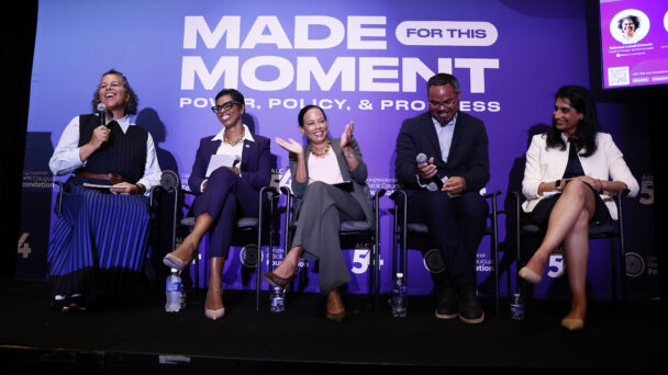 Five panelists sit in front of a purple sign that says "Made for this moment. Power, Policy, & Progress."