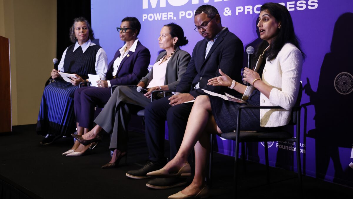 Five panelists sit in front of a purple sign that says "Made for this moment. Power, Policy, & Progress."