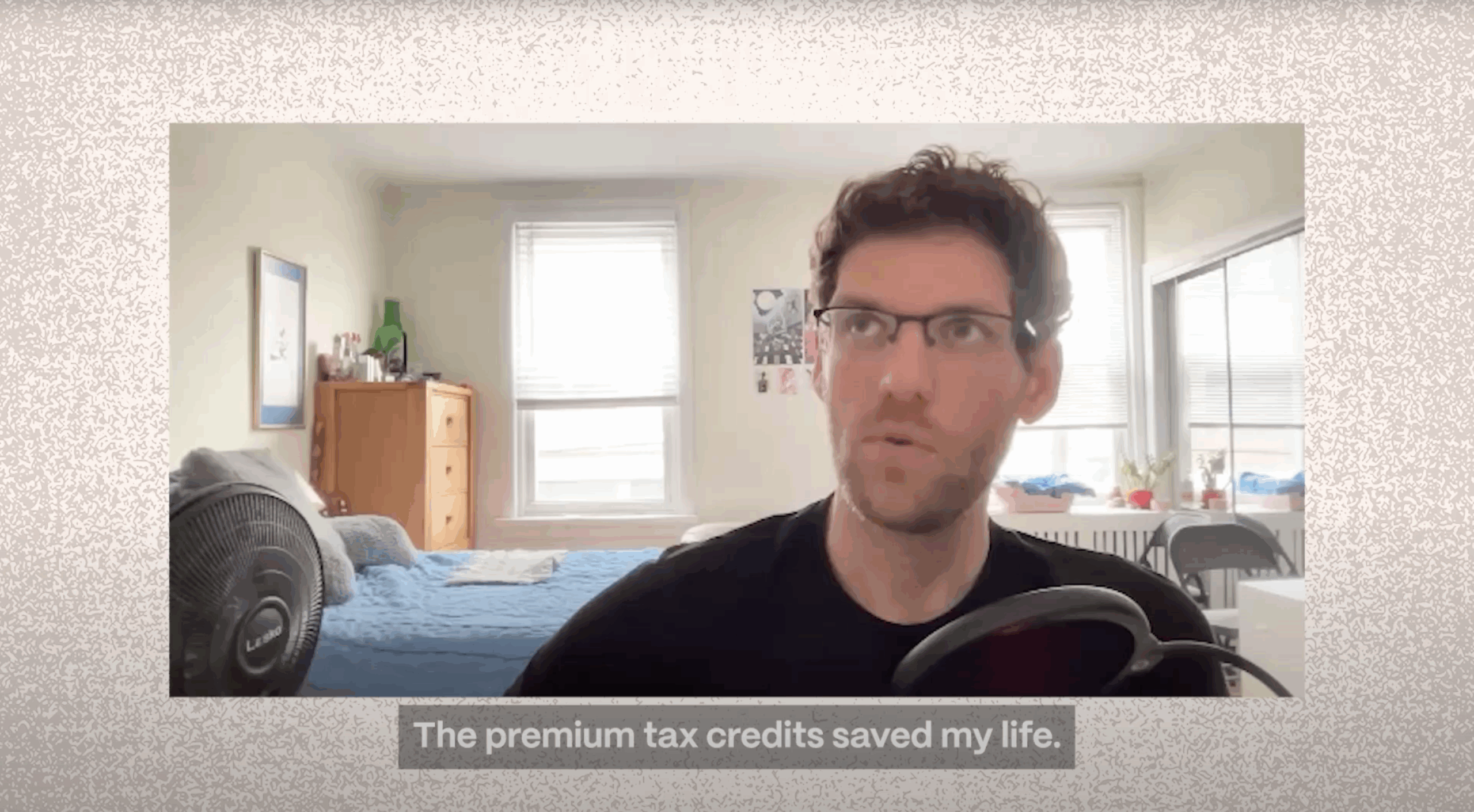 Jason wears glasses and a black shirt and sits in a bedroom. The caption reads "The premium tax credits saved my life."